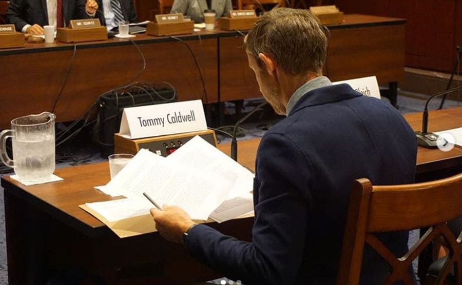 Tommy Caldwell sitting behind a desk testifying to the Senate Democrats special committee 