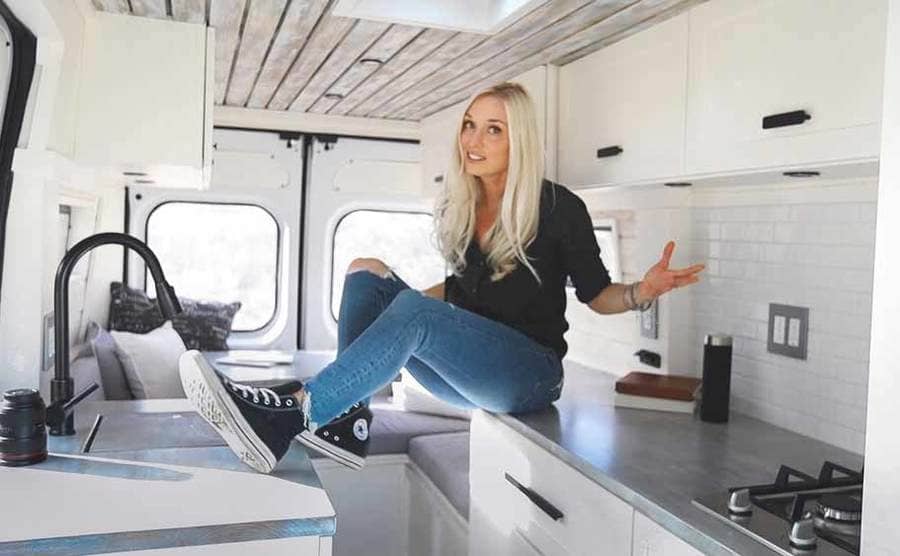 Christian sitting on her kitchen counter inside of her van 