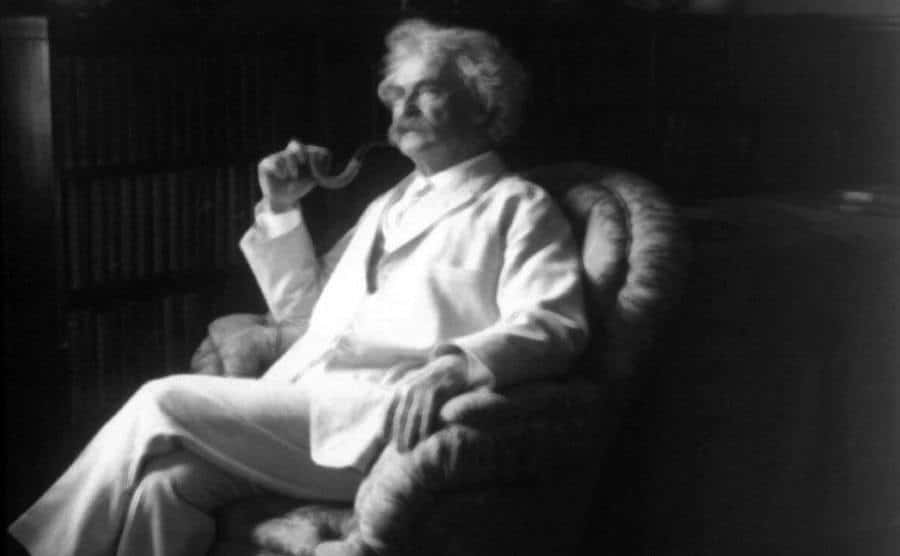A portrait of Mark Twain sitting at home.