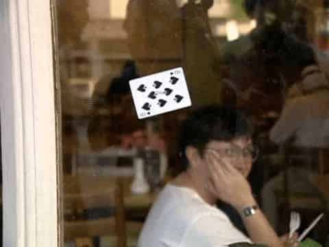 card on a window and a woman looking at it from inside